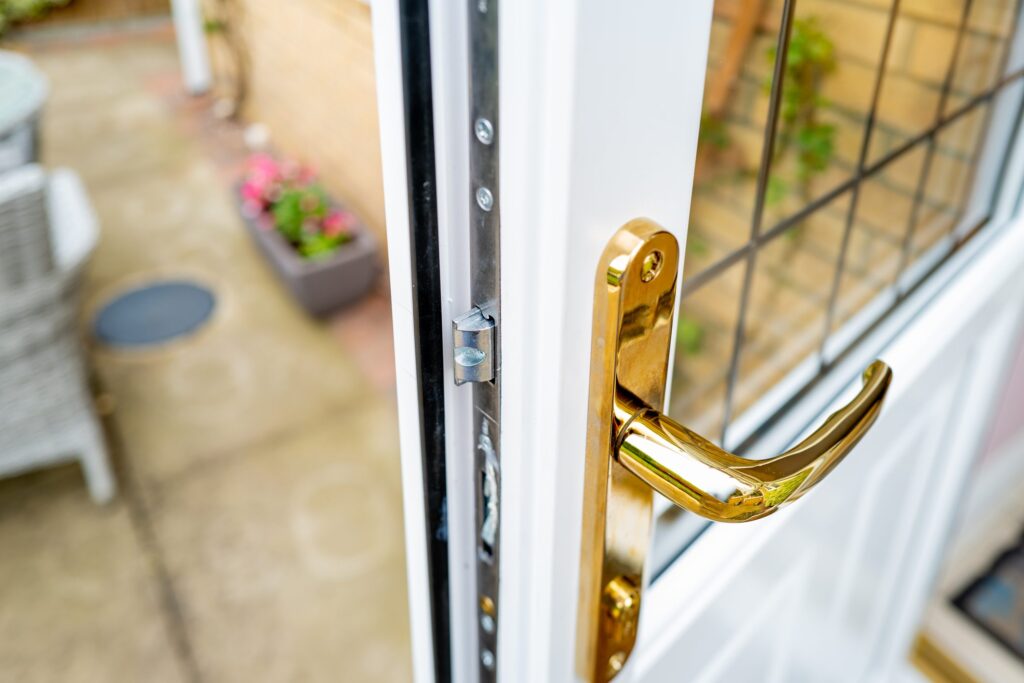 Shallow focus of the brass coloured door handle on a newly installed double glazed door